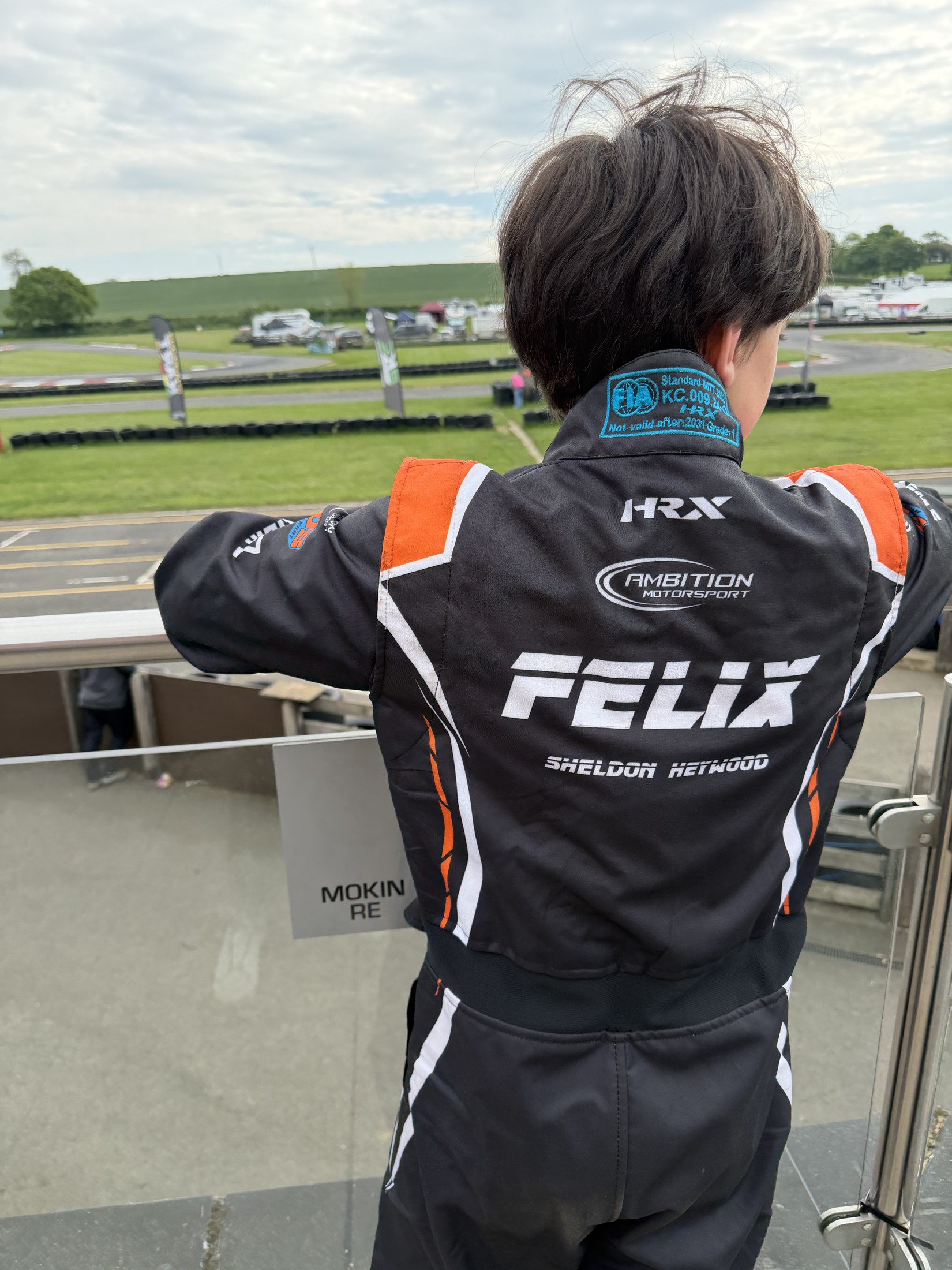 Felix looking across the circuit in his named racing suit